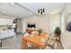 Open-concept dining area with stylish lighting, wood table set, and kitchen view at 3516 N Capitol Ave, Indianapolis, IN 46208
