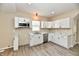 This modern kitchen boasts white cabinets, stainless steel appliances, and laminate flooring at 3516 N Capitol Ave, Indianapolis, IN 46208
