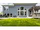 Well-maintained green backyard showing the home's blue exterior, a patio set, barbecue grills, and a covered hot tub at 3640 Snowdon Dr, Westfield, IN 46074