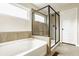 Modern bathroom featuring separate soaking tub and glass enclosed shower with decorative tile detail at 3640 Snowdon Dr, Westfield, IN 46074