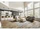 Open-concept living room with soaring windows, hardwood floors, and a seamless flow to the kitchen at 3640 Snowdon Dr, Westfield, IN 46074