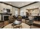 Comfortable lounge featuring fireplace, TV, leather chairs, and a view of the kitchen, perfect for entertaining at 3640 Snowdon Dr, Westfield, IN 46074