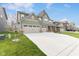 Home featuring three-car garage, brick accents, green siding, and manicured front lawn at 3737 Planck St, Danville, IN 46122