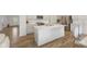 A modern kitchen with white cabinets, an island with seating, stainless steel appliances, and hardwood floors at 3737 Planck St, Danville, IN 46122