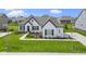 Stunning single-Gathering home with a white brick exterior, dark shutters, a gray roof and a perfectly manicured front lawn at 3840 Shady Lake Dr, Westfield, IN 46074
