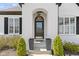 Close up of a stately front door featuring a beautiful archway, glass paned door, black planters and mature landscaping at 3840 Shady Lake Dr, Westfield, IN 46074