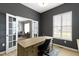 Bright home office with dark gray walls, light wood floors, a large desk and glass french doors that open to the sitting room at 3840 Shady Lake Dr, Westfield, IN 46074