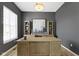 Stylishly appointed home office with dark gray walls, light wood floors, a large desk and decorative shelving at 3840 Shady Lake Dr, Westfield, IN 46074