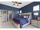 Comfortable bedroom with access to bathroom, wood furnishings, ceiling fan and navy blue accent wall and bedding at 3840 Shady Lake Dr, Westfield, IN 46074