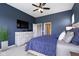 Comfortable bedroom with mounted TV, wood furnishings, ceiling fan and navy blue accent wall and bedding at 3840 Shady Lake Dr, Westfield, IN 46074