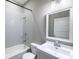 Clean bathroom with tiled shower-tub combo, white vanity, and modern lighting fixture at 3902 N Capitol Ave, Indianapolis, IN 46208
