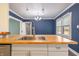 Kitchen island features a wooden countertop, stainless steel sink, and white shaker cabinets at 3967 N Park Ave, Indianapolis, IN 46205