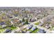 An aerial view showcases a neighborhood with mature trees, local buildings, and clear roads at 401 N Swope St, Greenfield, IN 46140