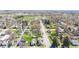 An aerial view shows neighborhood streets and tree-lined yards on a bright, sunny day at 401 N Swope St, Greenfield, IN 46140