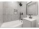 This modern bathroom features gray tile, a sleek vanity, and a bathtub with black fixtures at 401 N Swope St, Greenfield, IN 46140