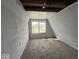 An attic room with neutral colored walls and carpet and two windows for natural light at 406 W Broadway St, Alexandria, IN 46001