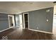 A bedroom featuring dark laminate flooring, neutral walls, closet with open doorway, and a partially seen ceiling fan at 406 W Broadway St, Alexandria, IN 46001