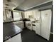 A kitchen featuring white appliances, cabinetry, black counter tops and a stainless steel sink at 406 W Broadway St, Alexandria, IN 46001