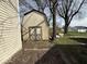 Weathered shed with double doors stands in the backyard, offering outdoor storage with trees in background at 406 W Broadway St, Alexandria, IN 46001