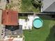 A birds eye view of the backyard with green grass, a pool, concrete pad and well maintained red roofed garage at 415 E 32Nd St, Indianapolis, IN 46205