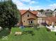 Spacious backyard with lush lawn, patio seating, garage, and mature trees at 415 E 32Nd St, Indianapolis, IN 46205