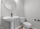 Stylish powder room with a round mirror, contemporary faucet, and white toilet at 4152 Dutton Dr, Bargersville, IN 46106