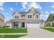 Charming two-story home with a well-manicured lawn, large windows and a two car garage on a beautiful sunny day at 4152 Dutton Dr, Bargersville, IN 46106