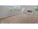 Bright living room with modern fireplace, wood-look flooring, and large windows with neighborhood views at 4152 Dutton Dr, Bargersville, IN 46106
