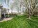 Lush backyard with green lawn, black fence, mature tree, and patio, creating a serene and private outdoor space at 4631 Belair Cir, Plainfield, IN 46168