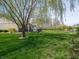 Spacious backyard featuring a beautiful weeping willow tree and a covered patio area at 4631 Belair Cir, Plainfield, IN 46168