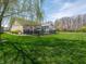 Spacious backyard featuring lush lawn, black fence, brick patio, mature trees and sunroom for tranquil outdoor living at 4631 Belair Cir, Plainfield, IN 46168