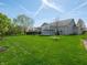 Expansive backyard with green grass, a patio, mature trees, and a sunroom, perfect for relaxation and outdoor activities at 4631 Belair Cir, Plainfield, IN 46168
