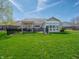 Well-maintained backyard with lush green lawn, black metal fence, brick patio, and sunroom for outdoor enjoyment at 4631 Belair Cir, Plainfield, IN 46168