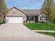Charming single-story home boasts a manicured lawn and an attached two-car garage at 4631 Belair Cir, Plainfield, IN 46168