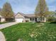 Well-maintained home with a two-car garage, mature trees, and a lush green lawn at 4631 Belair Cir, Plainfield, IN 46168