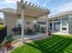 Brick patio with a pergola, grill, table, and chairs, overlooking a lush green lawn, ideal for outdoor entertaining at 4631 Belair Cir, Plainfield, IN 46168