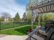 Inviting brick patio with pergola, comfortable chairs, lush green lawn, and privacy fence, ideal for relaxation at 4631 Belair Cir, Plainfield, IN 46168