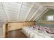 Unique loft bedroom under a sloped ceiling, showcasing built-in storage solutions and wood accents at 5110 Riverview Dr, Indianapolis, IN 46208
