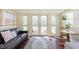 Bright sunroom with waterfront views featuring a cozy sitting area and a table for enjoying the scenery at 5110 Riverview Dr, Indianapolis, IN 46208