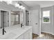 Well-lit bathroom featuring a double sink vanity, quartz countertops, and tiled shower at 5218 Triple Crown Way, Indianapolis, IN 46237