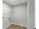 A laundry room with washer and dryer hookups, storage shelving, and plank flooring at 5218 Triple Crown Way, Indianapolis, IN 46237