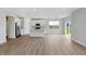 Bright, open-concept living area showcasing pristine hardwood floors and a modern kitchen at 5218 Triple Crown Way, Indianapolis, IN 46237