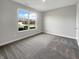 Bright bedroom with neutral walls, carpeted floors, and a view of the neighborhood at 5267 Chambers Ct, McCordsville, IN 46055