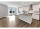 Open concept kitchen with white cabinets, stainless steel appliances and hardwood floors at 5267 Chambers Ct, McCordsville, IN 46055