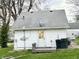 Back of the house with door to backyard, satellite dish, and yard debris at 5845 South St, Stilesville, IN 46180