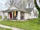 Charming home featuring a brick foundation, red front door, and a cozy front porch at 5845 South St, Stilesville, IN 46180
