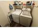 Convenient laundry area with washer, dryer, storage shelf, and neutral decor at 5845 South St, Stilesville, IN 46180