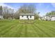 Manicured backyard showcasing a house, circular stone firepit and pristine lawn at 6107 Rural Dr, Indianapolis, IN 46227