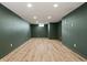 A spacious, finished basement with new vinyl flooring and neutral green painted walls at 6107 Rural Dr, Indianapolis, IN 46227