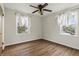 Cozy bedroom with ceiling fan, two windows, and hardwood floors at 6107 Rural Dr, Indianapolis, IN 46227